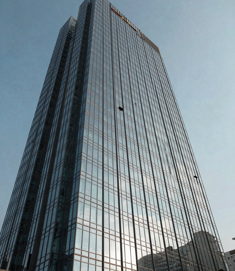 A low-angle shot of a modern glass skyscraper in Lahore reflecting a slate blue sky, emphasizing structural integrity and corporate scale.