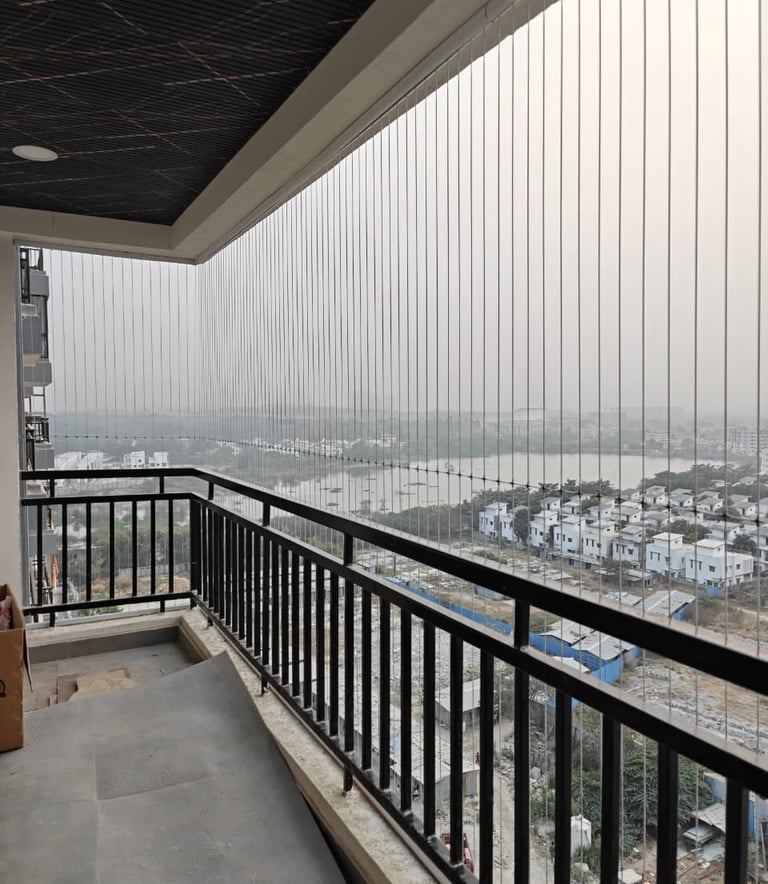 A close-up of a high-tensile stainless steel invisible grill installed on a luxury Hyderabad apartme