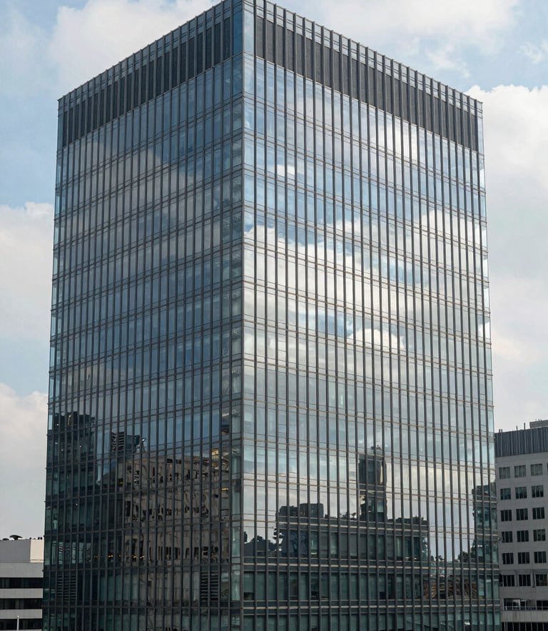A high-angle professional photograph of a modern glass office building in an International / Corporate Business district, with soft reflections of a light blue sky and white clouds, emphasizing architectural precision and a clean, global trade environment.
