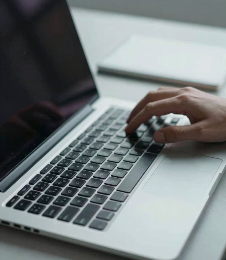 A close-up shot of a professional's hands typing on a high-end laptop in a sleek British / UK workspace, focus on technical precision, lighting in pale blue-grey tones.