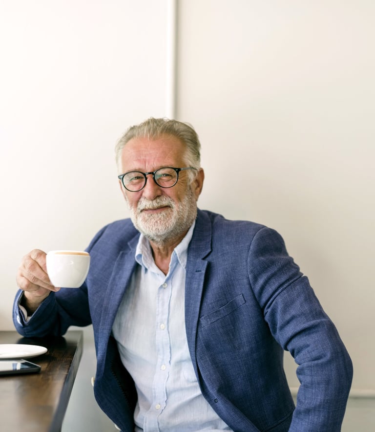 a man in a suit and glasses sitting at a desk