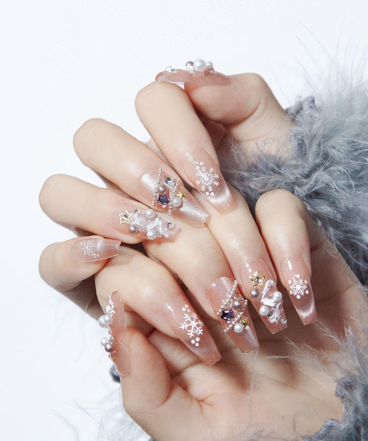 a woman's hand painted nails with a snowflaked design