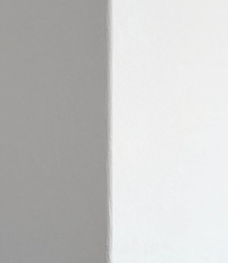 A close-up of a perfectly finished wall corner with smooth white texture, highlighting the meticulous attention to detail and craftsmanship. Natural, soft lighting with hints of #617488 and #B4C6D7 in the shadows to maintain brand consistency.