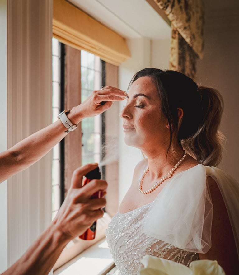 Bride having makeup applied in Leeds Airbnb – documentary wedding photography by The Wedding Edit