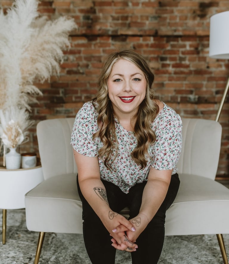 a woman smiling while sitting on a comfy white chair