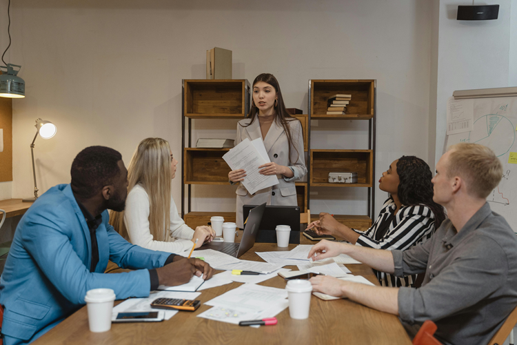 une cheffe d'équipe explique sa vision du team building à son équipe de 4 personnes