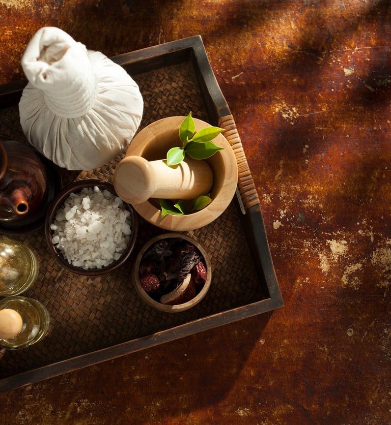 Plateau contenat des bols avec des plantes et du sel et des fioles avec des huiles