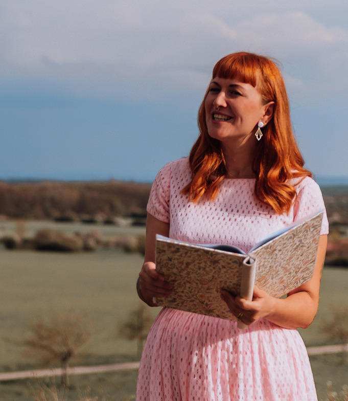 gefühlvoll blickt Ramona, Traurednerin, während der freien Trauung zum Hochzeitspaar während sie deren Geschichte erzählt