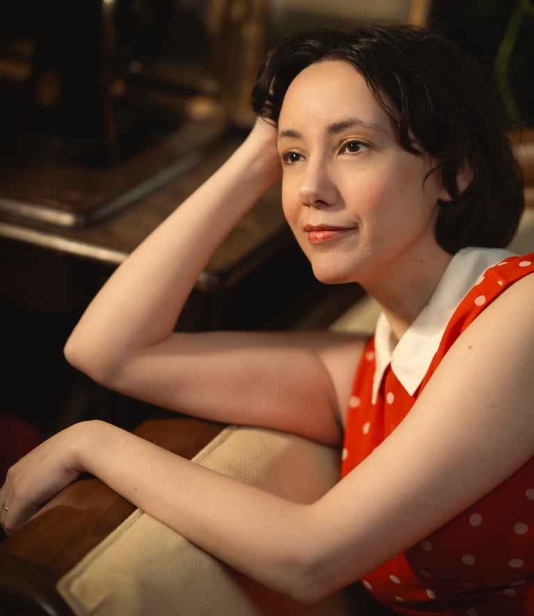 Maria in a read polkadot dress looking ahead