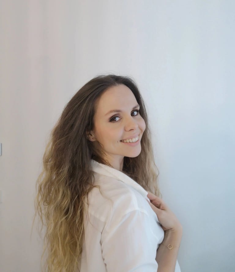 Christine Hauser, certified RTT Practitioner, wearing a white shirt and smiling over her shoulder