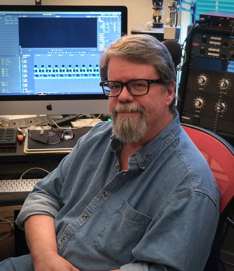 A photo a Jay Walsh, video editor, sitting at his desk.