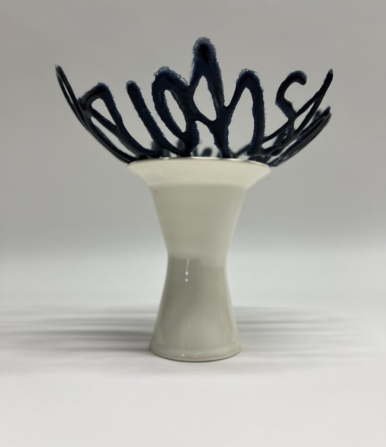 A blue glass bowl sculpture in the shape of a line of text, sitting on a porcelain ceramic pedestal