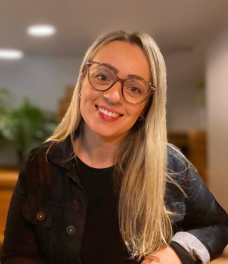 uma mulher de óculos e jaqueta preta sorrindo