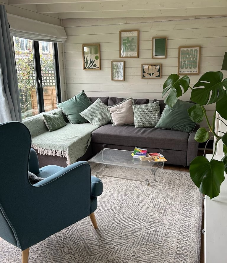 Calm counselling space with a sofa and armchair, plant and soft furnishings