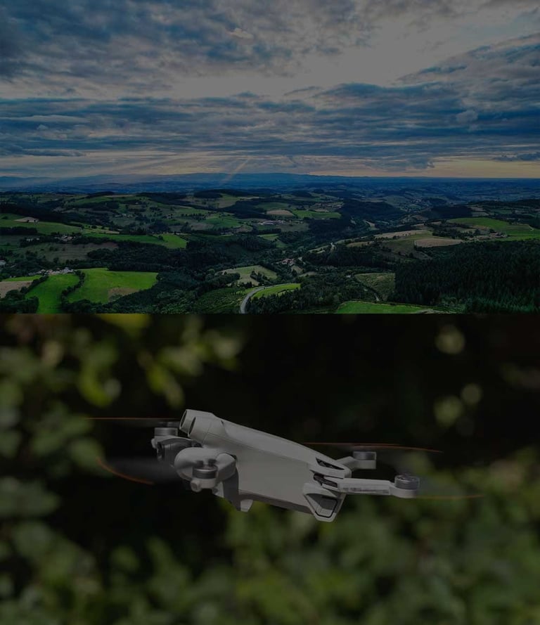 A compact camera drone flies over a scenic green valley under a cloudy sky.