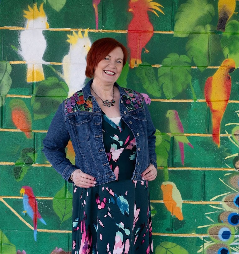 Dawn Vincent Celebrant standing in front of a colour mural