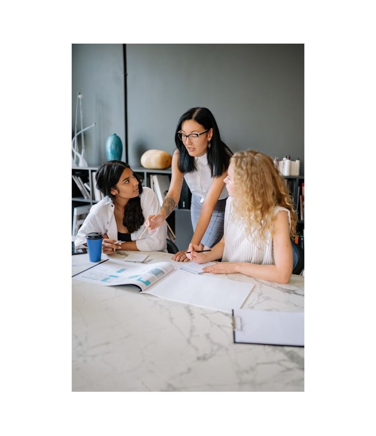 Diverse team of female colleagues collaborating on project details in a modern office.