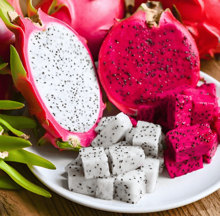 Fresh red and white dragon fruit sliced into halves and cubes on a white plate.