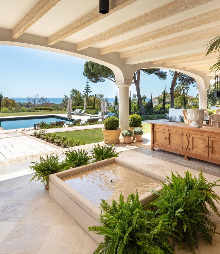 Covered terrace with fountain, pool and sea views