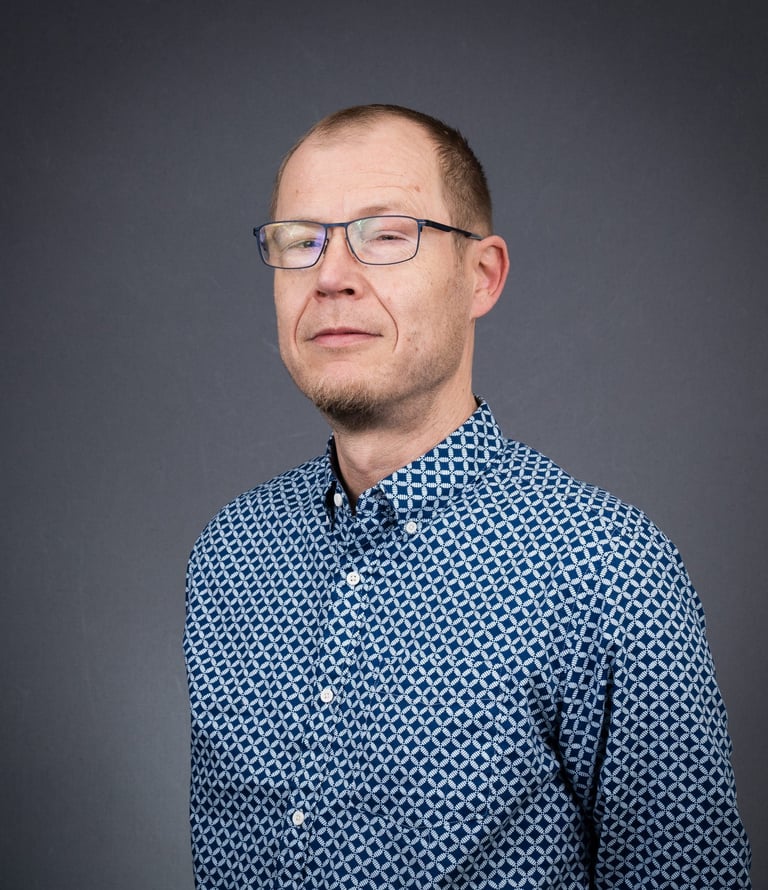 a man in a blue shirt and glasses