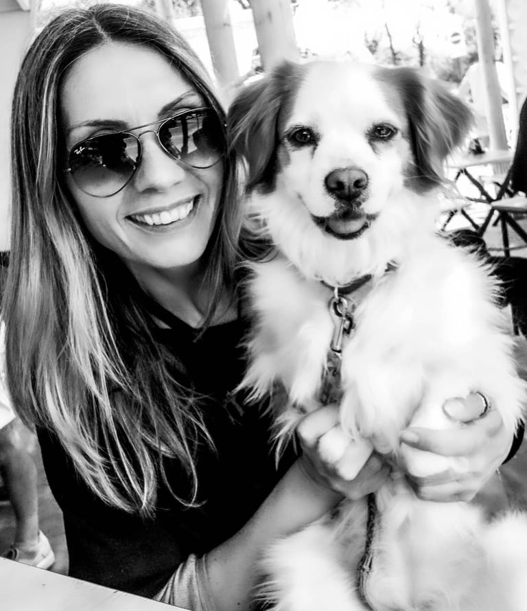 Black-and-white photograph of me, a pet photographer, hugging my dog Crika. We are close together, s