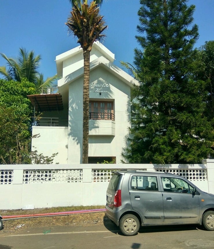 Completed exterior painting project: white house with palm tree in Pune”