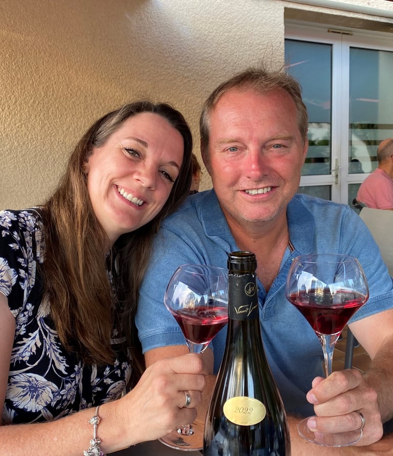 a man and woman are sitting at a table with wine glasses