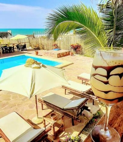 Una copa de cocktail en un balcón junto a la piscina