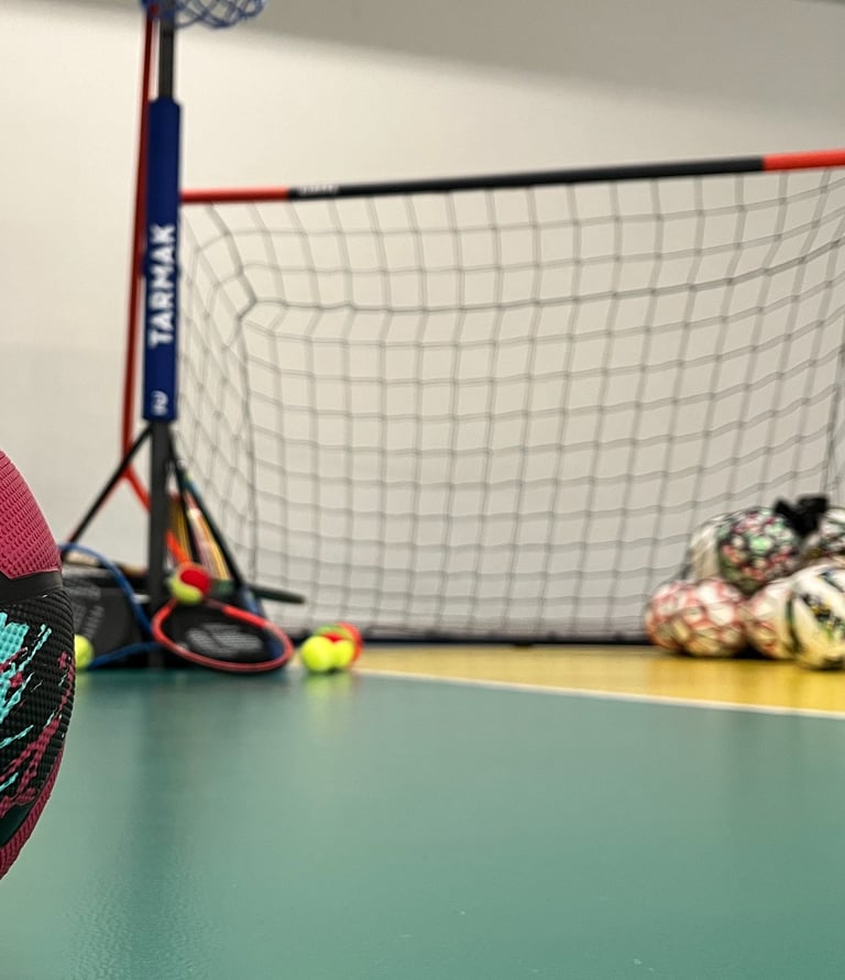 Primo piano di un pallone da basket rosa su un campo multisport nella palestra Move 2 Grow a Milano, con canestro, porta e al