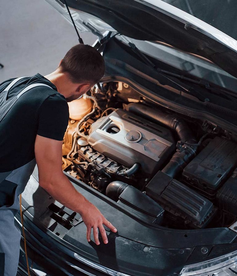 a man working on a car engine in a garage