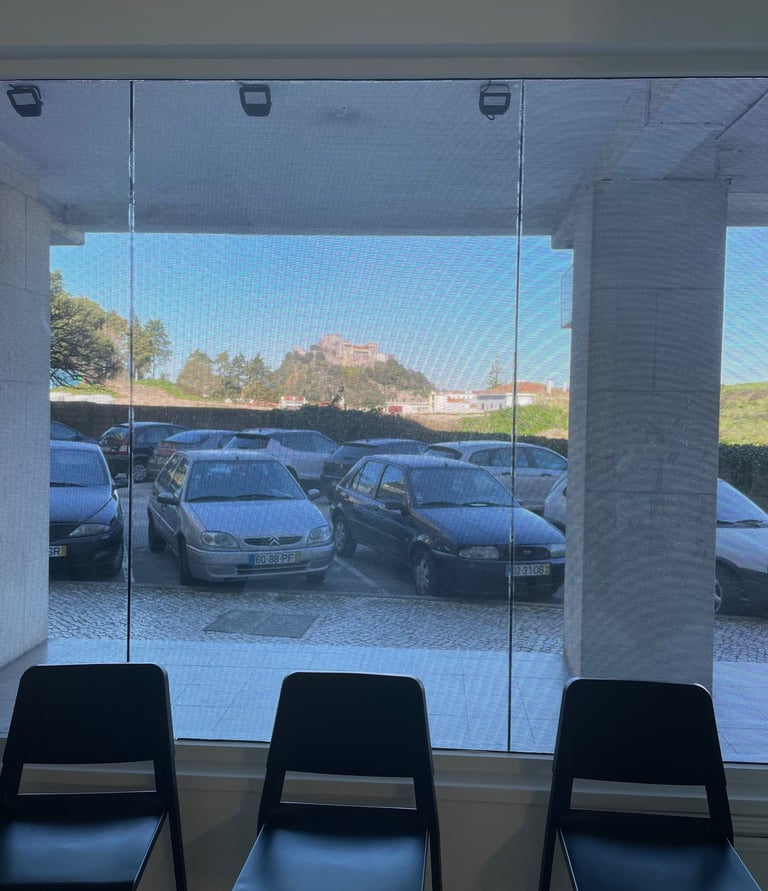 a row of chairs in a room with a view of a parking lot