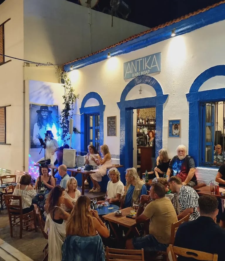 a group of people sitting at tables outside