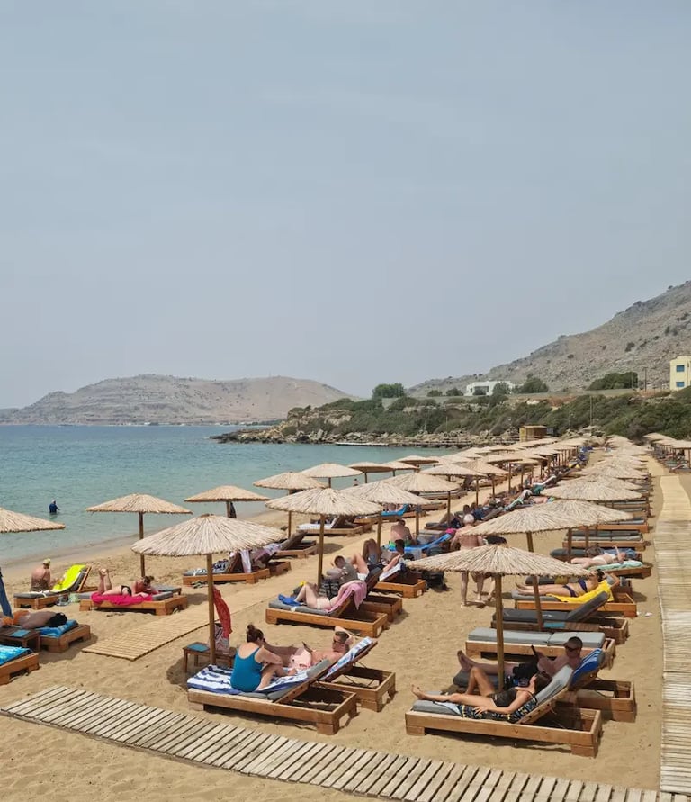 a beach with many people sitting on lounge chairs