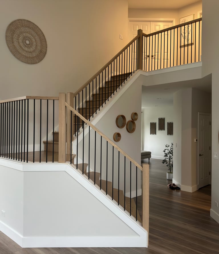 Custom oak staircase renovation with modern black iron railings in a Lake in the Hills home