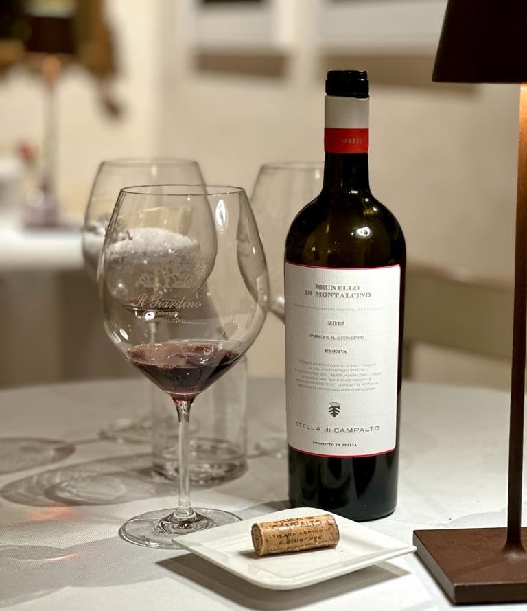 a wine bottle and wine glasses on a table