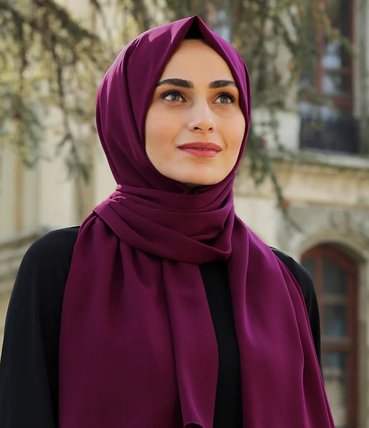 a woman wearing a purple scarf and a black top