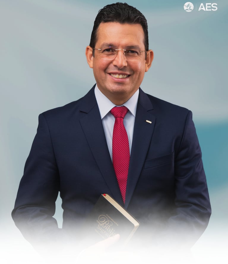 Smiling man in a navy suit and red tie holding a Holy Bible, representing religious leadership.