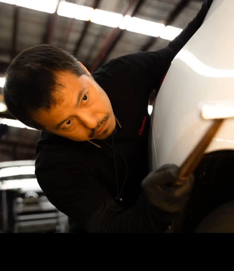Professional pdr technician blending a panel with hammer