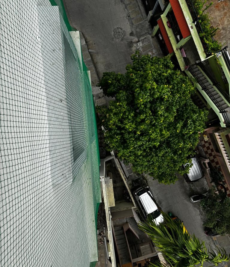 A happy child playing safely behind a well-installed safety net on a residential balcony.