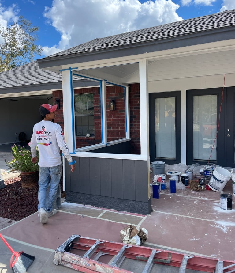 Professional house painter preparing a residential porch for exterior painting services.