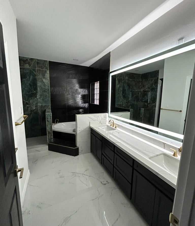 Modern master bathroom with double vanity, marble floors, backlit mirror, and luxury walk-in shower.