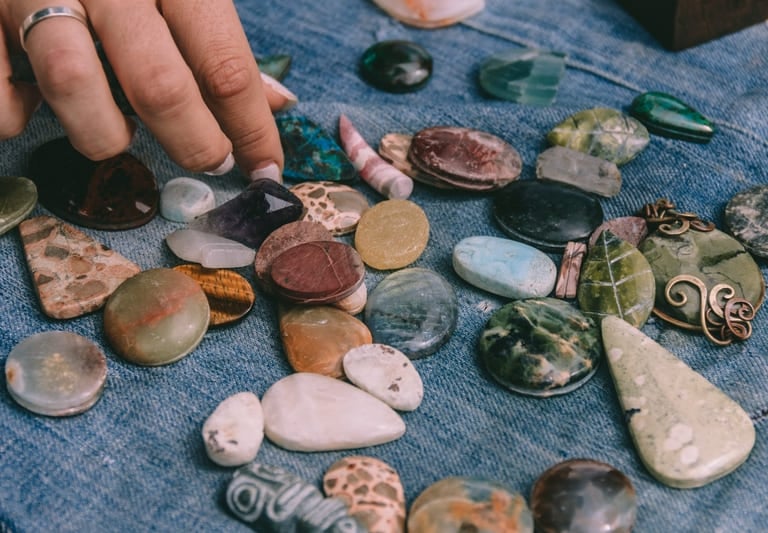 Una persona selecciona piedras semipreciosas pulidas y cristales de sanación