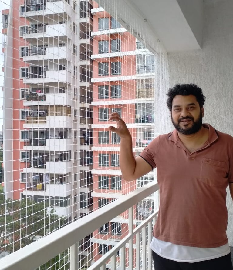 Close-up of a securely installed pigeon net on a Mumbai apartment balcony, sunlight filtering throug
