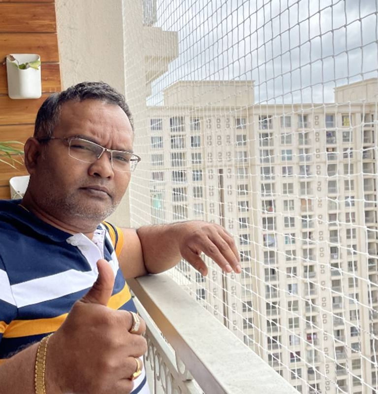 Technician carefully installing a pigeon net on a balcony in Marathahalli.