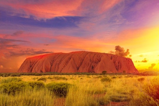 Uluru in Central Australia with the sun rising early in the morning after some rains
