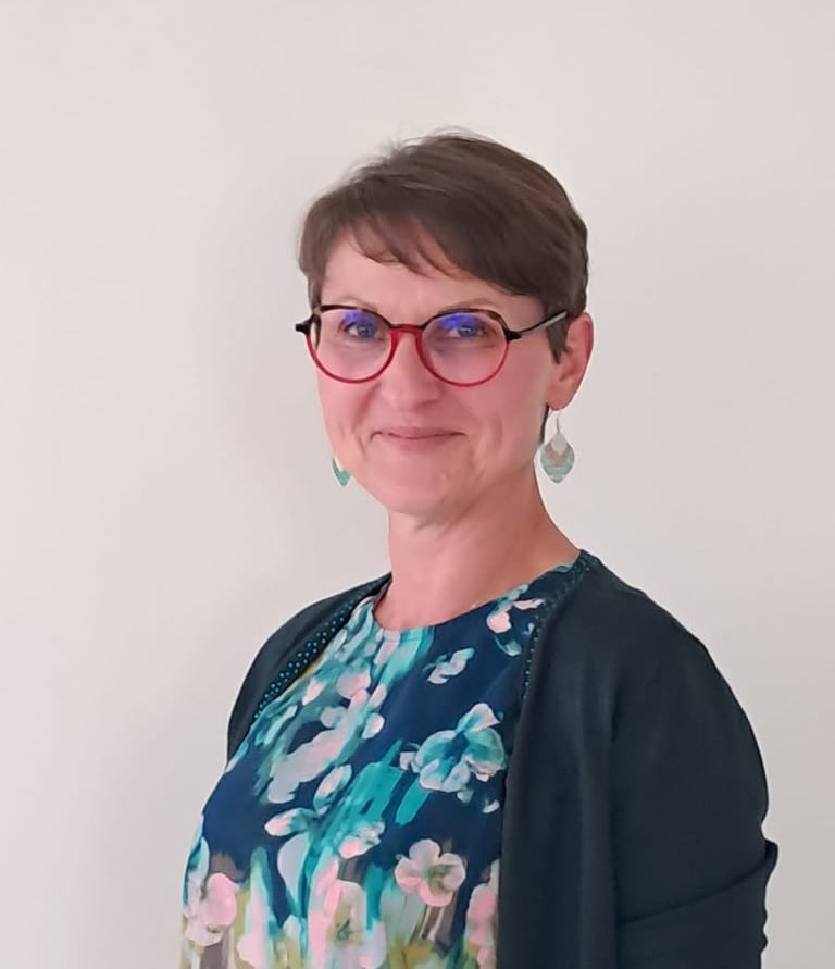 Photographie d'Emmanuelle, Gestalt Thérapeute. Femme chatain aux cheveux courts et lunettes