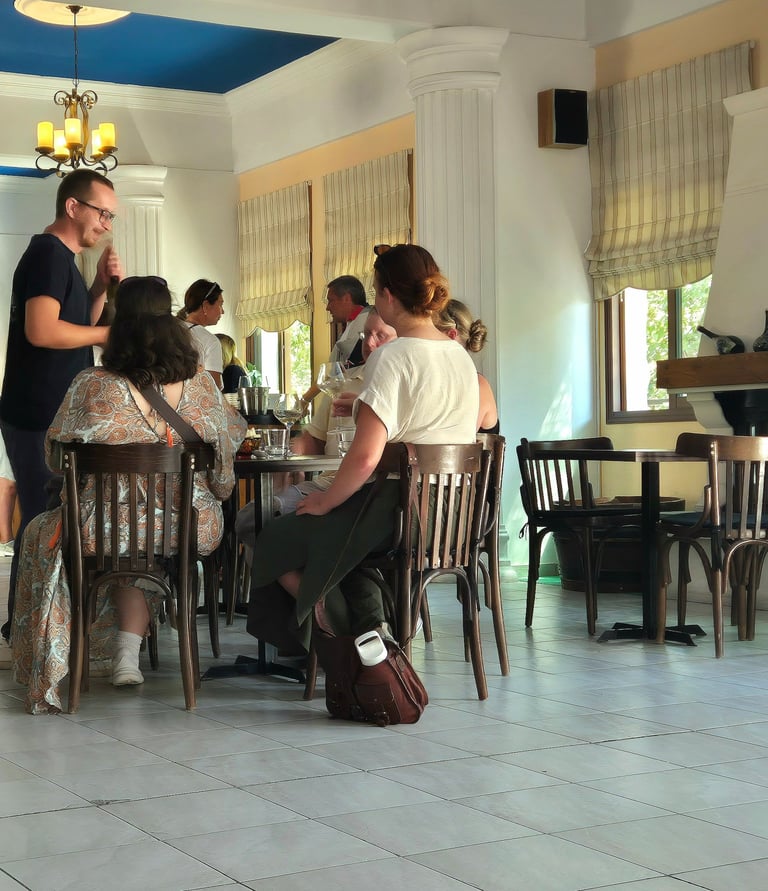 a group of people sitting at a table tasting wine 