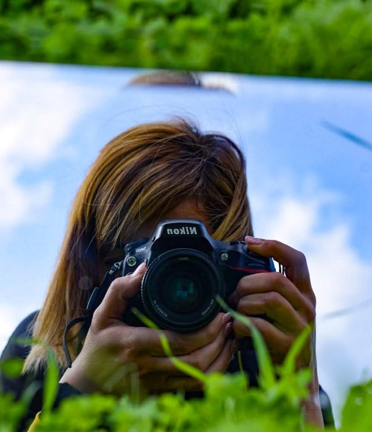 a woman taking a creative selfie with her camera using a mirror during a photography tour in Cyprus 