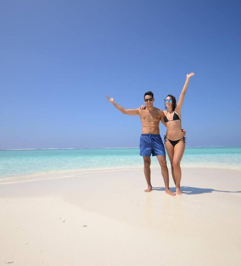 a man and woman standing on a beach