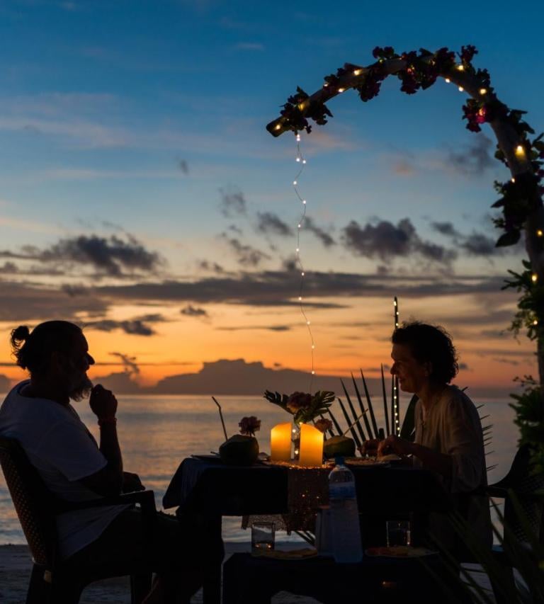 a couple sitting at a table with candles and candles